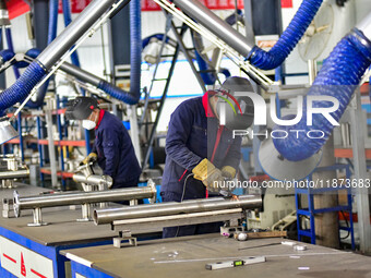 A worker works at a workshop of a water supply equipment manufacturing company in Qingzhou, China, on December 16, 2024. (