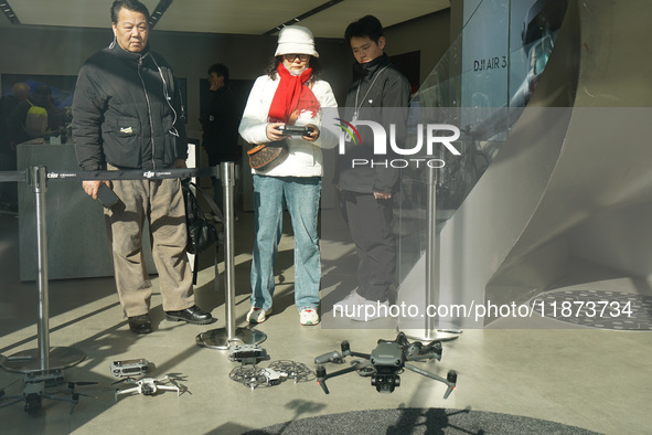 Customers try out drone products at the DJI flagship store in Shanghai, China, on December 16, 2024. 