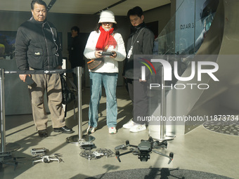 Customers try out drone products at the DJI flagship store in Shanghai, China, on December 16, 2024. (