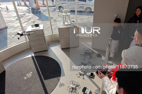 Customers try out drone products at the DJI flagship store in Shanghai, China, on December 16, 2024. 