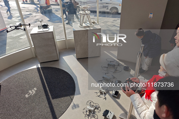 Customers try out drone products at the DJI flagship store in Shanghai, China, on December 16, 2024. 