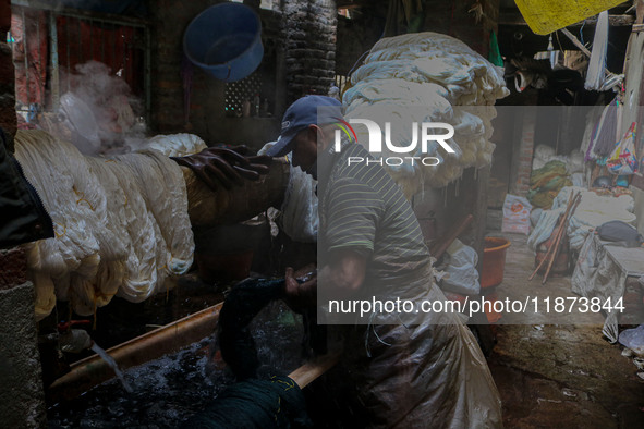 Farooq Ahmad washes threads inside a dyeing center in Srinagar, Jammu and Kashmir, on December 16, 2024. Kashmiris dye fabric and threads ma...