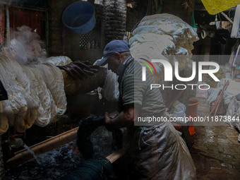 Farooq Ahmad washes threads inside a dyeing center in Srinagar, Jammu and Kashmir, on December 16, 2024. Kashmiris dye fabric and threads ma...