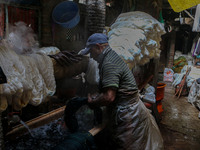 Farooq Ahmad washes threads inside a dyeing center in Srinagar, Jammu and Kashmir, on December 16, 2024. Kashmiris dye fabric and threads ma...