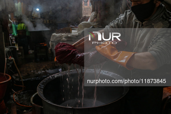 Waseem Khan dyes threads inside a dyeing center in Srinagar, Jammu and Kashmir, on December 16, 2024. Kashmiris dye fabric and threads manua...