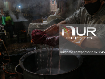 Waseem Khan dyes threads inside a dyeing center in Srinagar, Jammu and Kashmir, on December 16, 2024. Kashmiris dye fabric and threads manua...