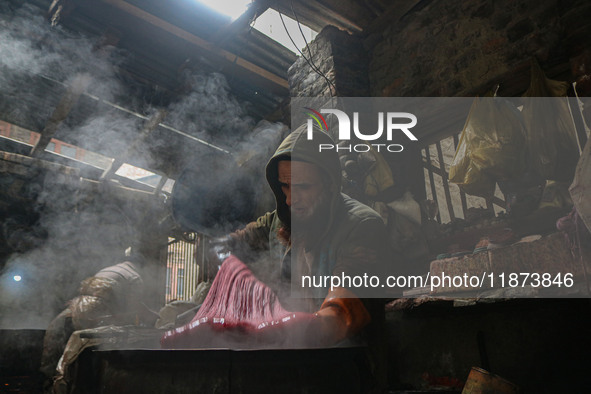 Ashiq Hussain Posh dyes threads inside a dyeing center in Srinagar, Jammu and Kashmir, on December 16, 2024. Kashmiris dye fabric and thread...