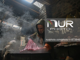 Ashiq Hussain Posh dyes threads inside a dyeing center in Srinagar, Jammu and Kashmir, on December 16, 2024. Kashmiris dye fabric and thread...