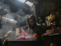 Ashiq Hussain Posh dyes threads inside a dyeing center in Srinagar, Jammu and Kashmir, on December 16, 2024. Kashmiris dye fabric and thread...