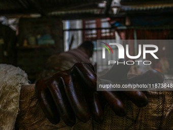 Gloves used while working on threads are left to air dry inside a dyeing center in Srinagar, Jammu and Kashmir, on December 16, 2024. Kashmi...