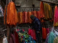 Maqsood Ahmad adjusts threads inside a dyeing center in Srinagar, Jammu and Kashmir, on December 16, 2024. Kashmiris dye fabric and threads...