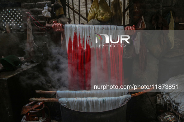 Ashiq Hussain Posh dyes threads inside a dyeing center in Srinagar, Jammu and Kashmir, on December 16, 2024. Kashmiris dye fabric and thread...