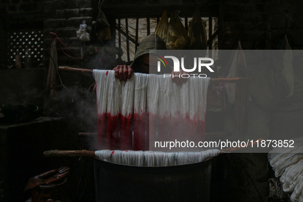 Ashiq Hussain Posh dyes threads inside a dyeing center in Srinagar, Jammu and Kashmir, on December 16, 2024. Kashmiris dye fabric and thread...