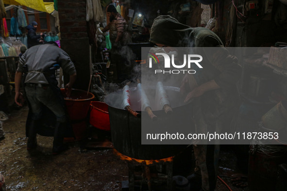 Ashiq Hussain Posh (right) and Waseem Khan (left) dye threads inside a dyeing center in Srinagar, Jammu and Kashmir, on December 16, 2024. K...