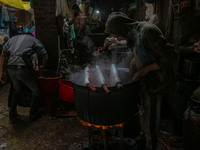 Ashiq Hussain Posh (right) and Waseem Khan (left) dye threads inside a dyeing center in Srinagar, Jammu and Kashmir, on December 16, 2024. K...