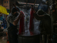 Ashiq Hussain Posh (right) and Waseem Khan (left) dye threads inside a dyeing center in Srinagar, Jammu and Kashmir, on December 16, 2024. K...