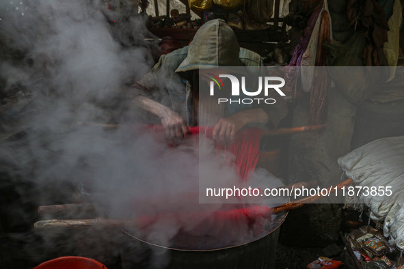 Ashiq Hussain Posh dyes threads inside a dyeing center in Srinagar, Jammu and Kashmir, on December 16, 2024. Kashmiris dye fabric and thread...