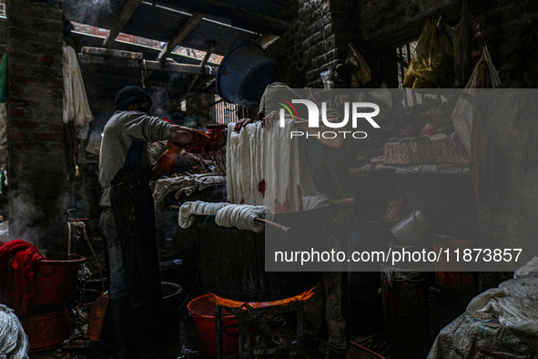 Ashiq Hussain Posh (right) and Waseem Khan (left) dye threads inside a dyeing center in Srinagar, Jammu and Kashmir, on December 16, 2024. K...