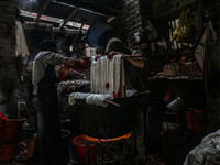 Ashiq Hussain Posh (right) and Waseem Khan (left) dye threads inside a dyeing center in Srinagar, Jammu and Kashmir, on December 16, 2024. K...