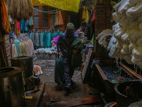 Maqsood Ahmad carries threads inside a dyeing center in Srinagar, Jammu and Kashmir, on December 16, 2024. Kashmiris dye fabric and threads...