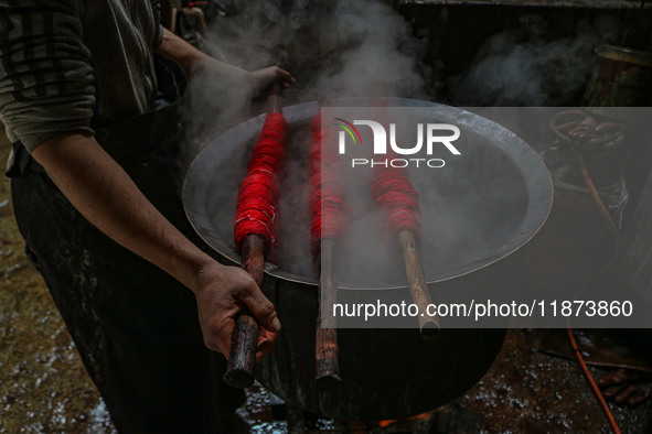 Waseem Khan dyes threads inside a dyeing center in Srinagar, Jammu and Kashmir, on December 16, 2024. Kashmiris dye fabric and threads manua...