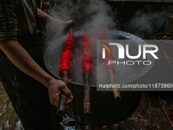 Waseem Khan dyes threads inside a dyeing center in Srinagar, Jammu and Kashmir, on December 16, 2024. Kashmiris dye fabric and threads manua...