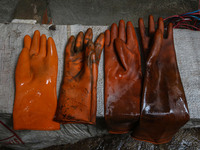 Gloves used while working on threads are left to air dry inside a dyeing center in Srinagar, Jammu and Kashmir, on December 16, 2024. Kashmi...