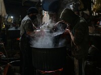 Ashiq Hussain Posh (right) and Waseem Khan (left) dye threads inside a dyeing center in Srinagar, Jammu and Kashmir, on December 16, 2024. K...