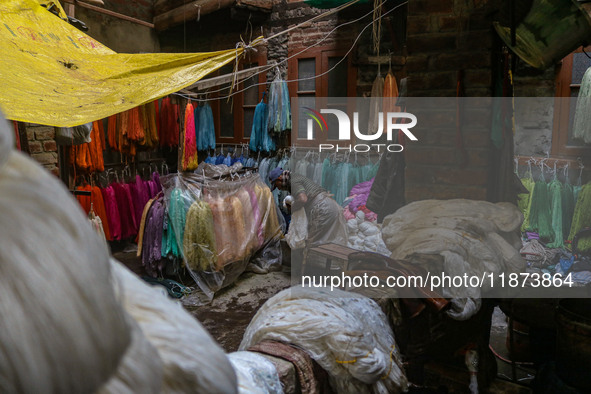 Farooq Ahmad arranges threads inside a dyeing center in Srinagar, Jammu and Kashmir, on December 16, 2024. Kashmiris dye fabric and threads...