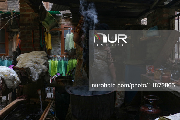 Tariq Ahmad Posh dyes threads inside a dyeing center in Srinagar, Jammu and Kashmir, on December 16, 2024. Kashmiris dye fabric and threads...