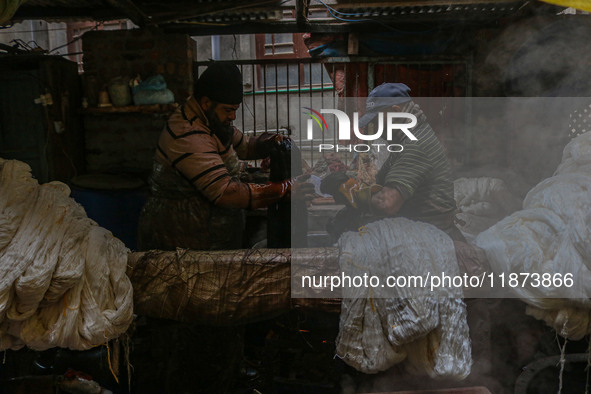 Farooq Ahmad (right) and Tariq Ahmad Posh (left) dye threads inside a dyeing center in Srinagar, Jammu and Kashmir, on December 16, 2024. Ka...