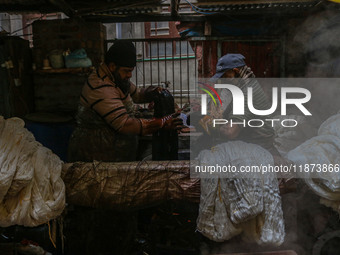 Farooq Ahmad (right) and Tariq Ahmad Posh (left) dye threads inside a dyeing center in Srinagar, Jammu and Kashmir, on December 16, 2024. Ka...