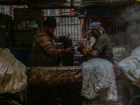 Farooq Ahmad (right) and Tariq Ahmad Posh (left) dye threads inside a dyeing center in Srinagar, Jammu and Kashmir, on December 16, 2024. Ka...