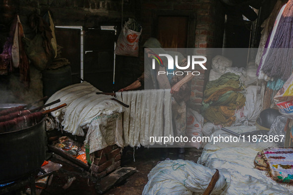 Ashiq Hussain Posh arranges threads inside a dyeing center in Srinagar, Jammu and Kashmir, on December 16, 2024. Kashmiris dye fabric and th...