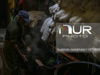 Farooq Ahmad washes threads inside a dyeing center in Srinagar, Jammu and Kashmir, on December 16, 2024. Kashmiris dye fabric and threads ma...