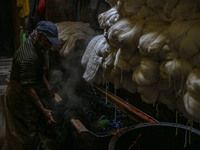 Farooq Ahmad washes threads inside a dyeing center in Srinagar, Jammu and Kashmir, on December 16, 2024. Kashmiris dye fabric and threads ma...