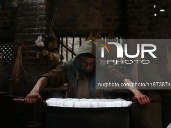 Ashiq Hussain Posh dyes threads inside a dyeing center in Srinagar, Jammu and Kashmir, on December 16, 2024. Kashmiris dye fabric and thread...