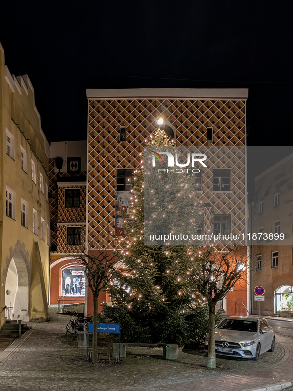 Historic buildings glow with colorful Christmas light projections in Wasserburg am Inn, Bavaria, Germany, on December 15, 2024. The historic...