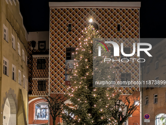 Historic buildings glow with colorful Christmas light projections in Wasserburg am Inn, Bavaria, Germany, on December 15, 2024. The historic...