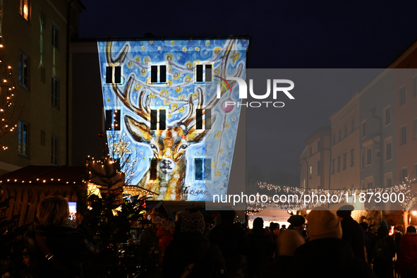 Historic buildings glow with colorful Christmas light projections in Wasserburg am Inn, Bavaria, Germany, on December 15, 2024. The historic...