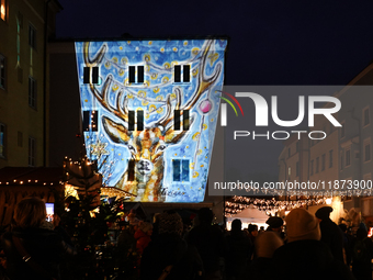 Historic buildings glow with colorful Christmas light projections in Wasserburg am Inn, Bavaria, Germany, on December 15, 2024. The historic...