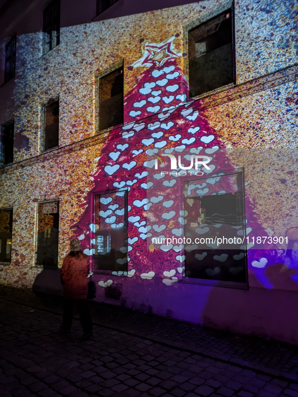 Historic buildings glow with colorful Christmas light projections in Wasserburg am Inn, Bavaria, Germany, on December 15, 2024. The historic...