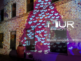 Historic buildings glow with colorful Christmas light projections in Wasserburg am Inn, Bavaria, Germany, on December 15, 2024. The historic...