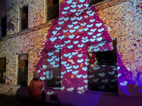 Historic buildings glow with colorful Christmas light projections in Wasserburg am Inn, Bavaria, Germany, on December 15, 2024. The historic...