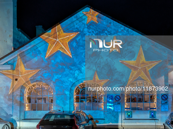 Historic buildings glow with colorful Christmas light projections in Wasserburg am Inn, Bavaria, Germany, on December 15, 2024. The historic...