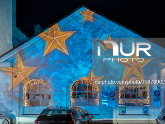 Historic buildings glow with colorful Christmas light projections in Wasserburg am Inn, Bavaria, Germany, on December 15, 2024. The historic...