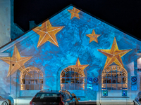 Historic buildings glow with colorful Christmas light projections in Wasserburg am Inn, Bavaria, Germany, on December 15, 2024. The historic...