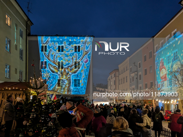 Historic buildings glow with colorful Christmas light projections in Wasserburg am Inn, Bavaria, Germany, on December 15, 2024. The historic...