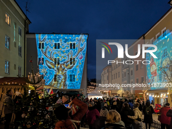 Historic buildings glow with colorful Christmas light projections in Wasserburg am Inn, Bavaria, Germany, on December 15, 2024. The historic...