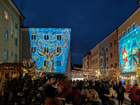 Historic buildings glow with colorful Christmas light projections in Wasserburg am Inn, Bavaria, Germany, on December 15, 2024. The historic...